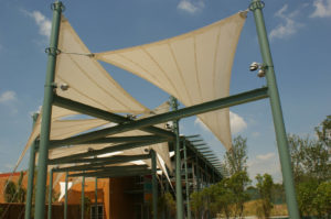 Shade structures outside the San Antonio, Texas, DoSeum—a museum “where children learn by doing”—contribute to the museum’s sustainable focus. The building is slated to receive LEED Gold certification, and the fabric shade elements in the outdoor exhibit areas, interlaced with water features, help provide a climate-friendly space for children to learn. The Chism Company used shade fabric tensioned between powder-coat painted steel masts and attached to welded steel rings at the top of the masts. A combination of galvanized and powder coated fittings includes clevis ends with shackles on two points and a turnbuckle on the third point of each shade. Photo: The Chism Company.